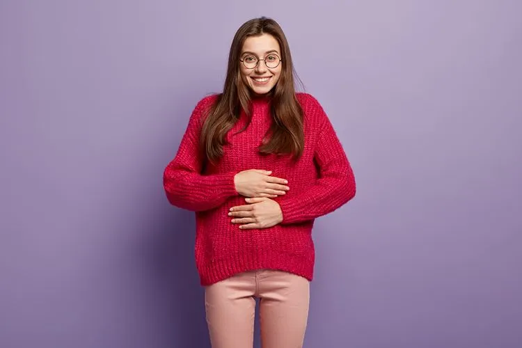 Woman with hands on stomach — gut health including Akkermansia plays an important role in metabolic and digestive wellbeing